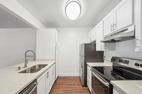 Belmont apartment for rent - an empty kitchen with white cabinets and stainless steel appliances