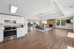Belmont apartment for rent - the living room and kitchen of a new home with white cabinets and a fireplace