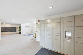 Belmont apartment for rent - a walk in closet with white cabinets and a bench in a room with a rug