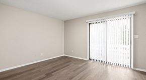 Carmel apartment for rent - an empty living room with a large window and wood flooring