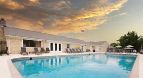 Carmel apartment for rent - a large swimming pool in front of a hotel with a building