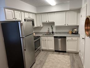 Columbus apartment for rent - a kitchen with stainless steel appliances and white cabinets