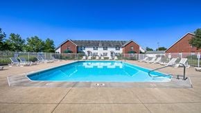 Grove City apartment for rent - a swimming pool with chairs around it in front of a house