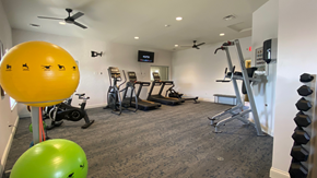 Grove City apartment for rent - a gym with exercise equipment and a yellow ball on the floor