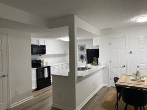 Grove City apartment for rent - A kitchen with a black fridge and a black microwave.