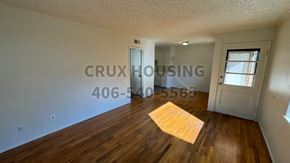 Havre apartment for rent - A room with wooden floors and a door leading to another room.