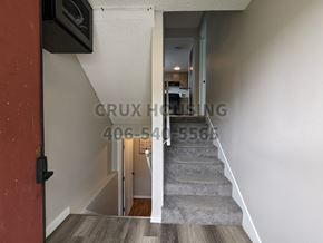 Great Falls apartment for rent - A stairway with a carpeted runner and wooden steps leading to a hallway.