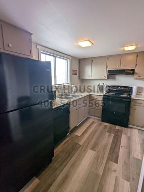 Great Falls apartment for rent - A kitchen with a black fridge and wooden floors.