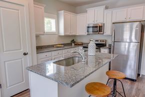 Oakwood apartment for rent - a kitchen with white cabinets and a granite counter top