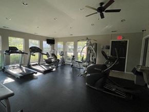 Hebron apartment for rent - A gym with treadmills, elliptical machines, and a fan.