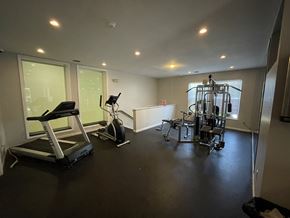 Cincinnati apartment for rent - A spacious gym with a treadmill, exercise bike, and weightlifting equipment.