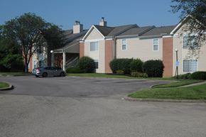 Cincinnati apartment for rent - A car is parked in front of a building with a brick facade.
