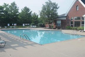 Hebron apartment for rent - A swimming pool with a diving board and a building in the background.