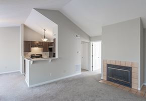 Ft Mitchell apartment for rent - A living room with a fireplace and a kitchen area in the background.