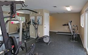 Crescent Springs apartment for rent - A gym with a variety of equipment including treadmills, elliptical machines, and weight machines.