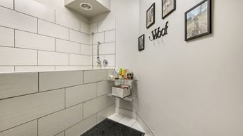A bathroom with white tiles and a shower and a sink