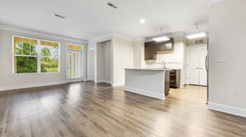 An empty living room and kitchen with a large window