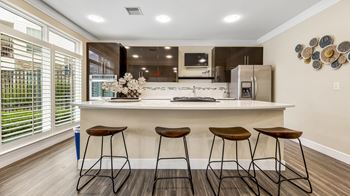 A kitchen with a large island with three stools
