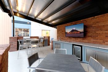 A patio with a table and chairs and a tv
