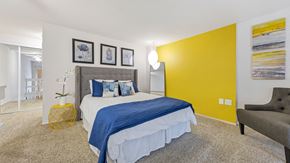 St. Louis apartment for rent - a bedroom with a yellow accent wall and a bed at Park 44, St. Louis, 63108