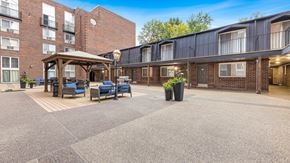 St. Louis apartment for rent - a courtyard with furniture and a gazebo in front of a brick building at Park 44 Apartments in St. Louis, MO, 63108