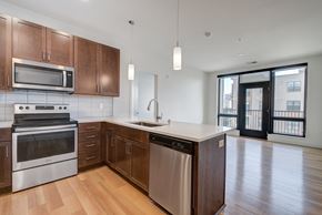 Franklin apartment for rent - an empty kitchen with wooden cabinets and stainless steel appliances at Statesman Apartments, Franklin, WI