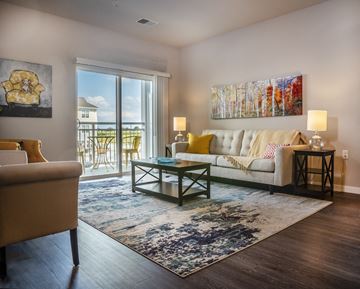 Fitchburg apartment for rent - a living room with a white couch and a sliding glass door to a balcony