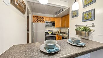 A kitchen with stainless steel appliances and a counter with two cups