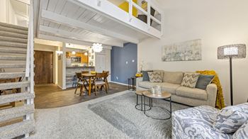 A living room with a couch and a table and a kitchen