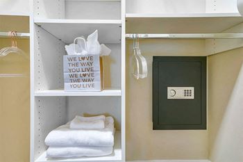A shelf with towels and a door in a bathroom