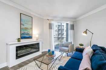 A living room with a blue couch and a fireplace