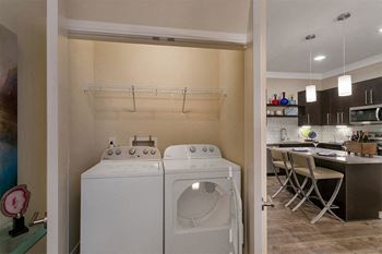 A washer and dryer in a laundry room next to a kitchen