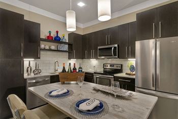 A kitchen with stainless steel appliances and a table