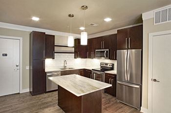 A kitchen with stainless steel appliances and wooden cabinets