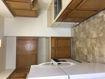 Kalamazoo apartment for rent - A kitchen with a white counter top and wooden cabinets.