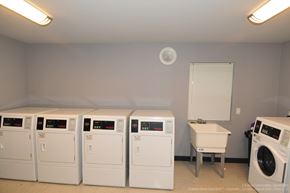 Kalamazoo apartment for rent - A row of white front load washing machines in a laundry room.