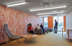 Detroit apartment for rent - A group of people are sitting in a room with orange wallpaper.