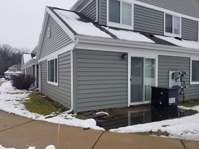 Kalamazoo apartment for rent - A house with a grey siding and a black mailbox.
