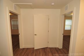 Kalamazoo apartment for rent - A white door is in the middle of a room with wood floors.