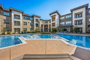 Denton apartment for rent - A large swimming pool in front of apartment buildings.