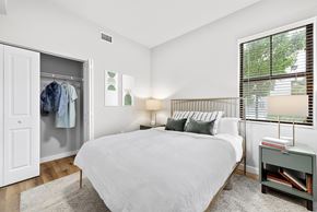 Miami apartment for rent - a bedroom with a large white bed and a large window
