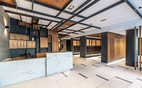 Brooklyn apartment for rent - A modern office lobby with a white marble reception desk and wooden accents.