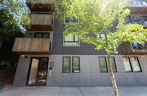 Brooklyn apartment for rent - A modern building with a tree in front of it.