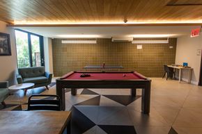 Brooklyn apartment for rent - A room with a pool table and a green couch.