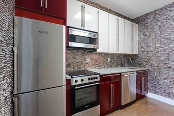 Brooklyn apartment for rent - A kitchen with a stainless steel refrigerator, oven, and microwave.