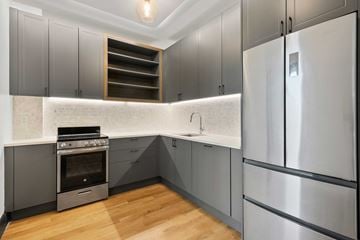 Brooklyn apartment for rent - A modern kitchen with a stainless steel refrigerator and a built-in oven.