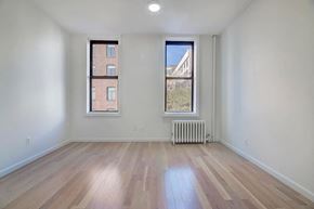 Brooklyn apartment for rent - an empty living room with a radiator and two windows