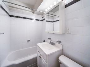 New York apartment for rent - A white bathroom with a tub, sink, and toilet.