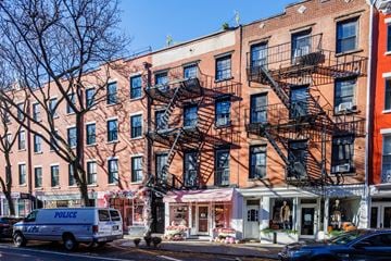 New York apartment for rent - a building on a city street with a police van