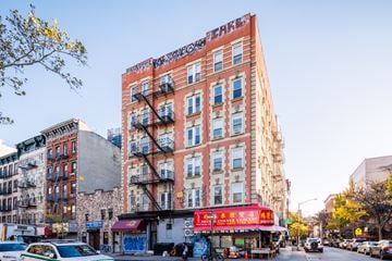 New York apartment for rent - a tall building on a city street with cars